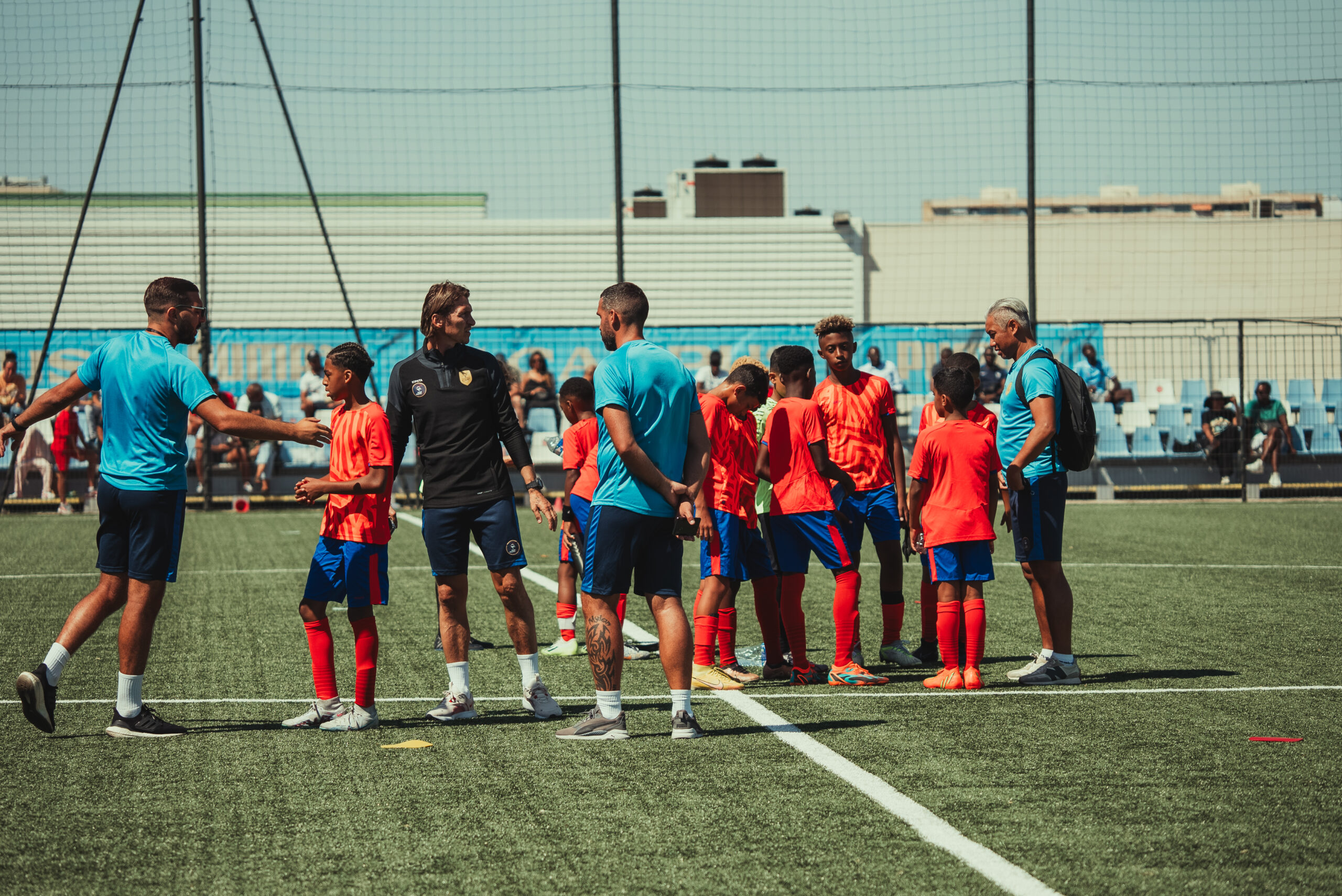 Joueurs et encadrants réunis sur le terrain lors de Team France × OM en 2023